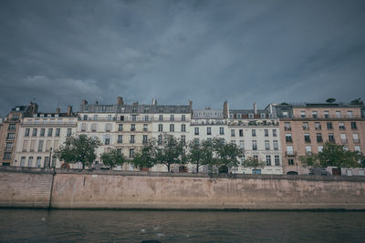 Buildings in city against cloudy sky