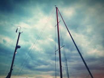 Low angle view of mast against cloudy sky
