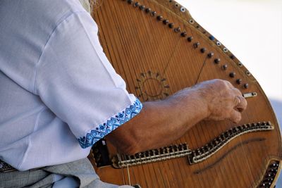 Midsection of man playing guitar