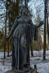 Statue in winter forest