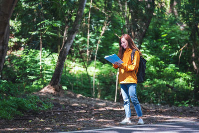 Portrait of young woman standing in forest