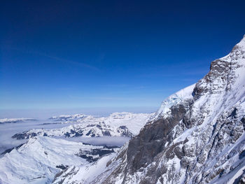 Scenic view of snow covered landscape against clear blue sky