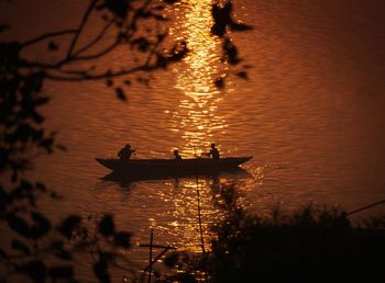 Silhouette boats in lake against sky during sunset