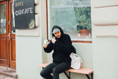 Full length of man sitting in front of window