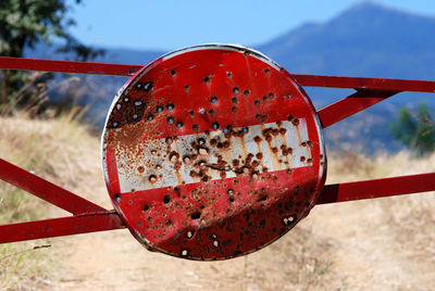 Close-up of rusty metal fence on field against sky