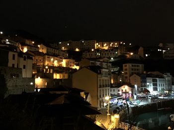 Illuminated cityscape against sky at night