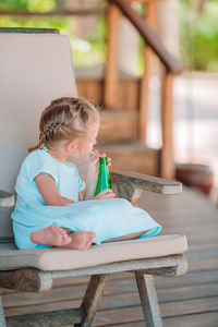 Full length of girl sitting on chair