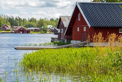 Houses by lake against sky