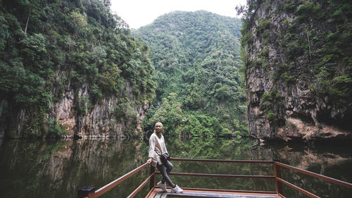 Women standing on footbridge over river in forest