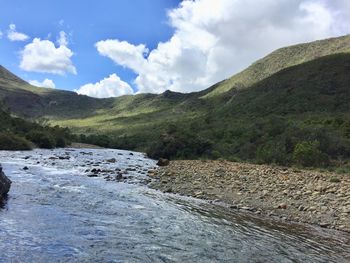 Scenic view of river amidst mountains against sky