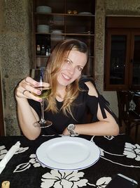 Portrait of a smiling young woman sitting at restaurant table