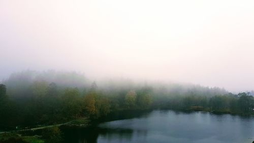 Scenic view of lake against sky during foggy weather