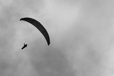 Low angle view of person paragliding against sky