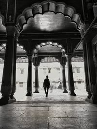 Rear view of man walking in corridor of building