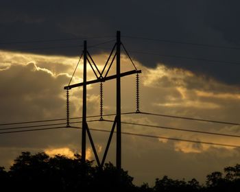 Low angle view of silhouette electricity pylon against sky, invokes a martini glass