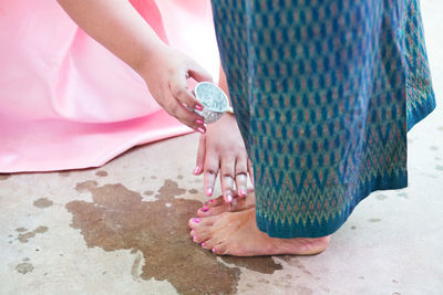Person washing woman feet on ground
