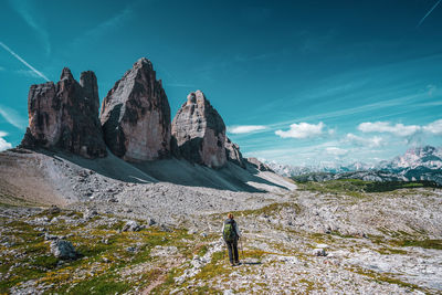 Backpacker on hiking trails in the dolomites, italy. view of the three peaks.