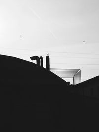 Low angle view of silhouette built structure against sky