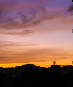 Silhouette buildings against sky during sunset