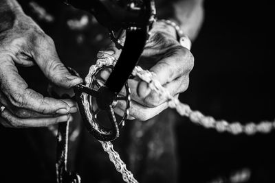 Cropped hands of man repairing chain of bicycle