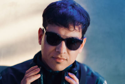 Close-up portrait of handsome man wearing sunglasses and headphones