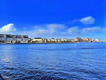 City by sea against blue sky