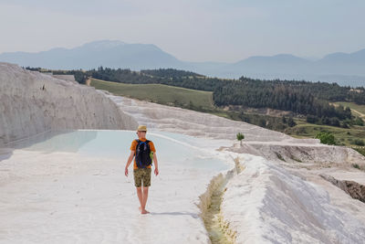 Man walking in famous touristic location, exploring travertine pools at pamukkale, turkey