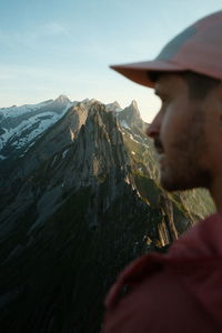 Man hiking mountain range in the swiss alps during sunset. shot on fujifilm x100v. blurry foreground