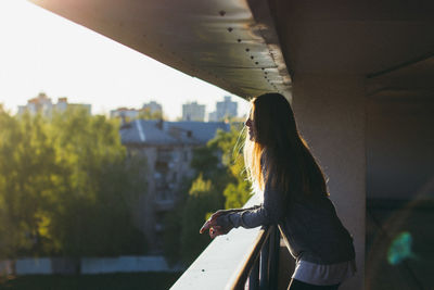 Side view of woman standing on balcony