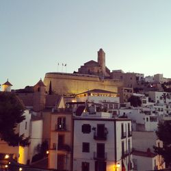 Buildings in city against clear sky