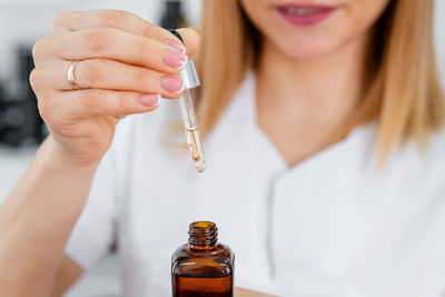 Vitamins for the restoration and renewal of the face. girl applies face serum