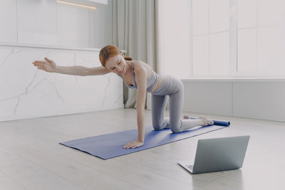 Full length of woman exercising in gym