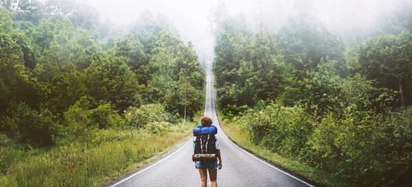 Rear view of man walking on road