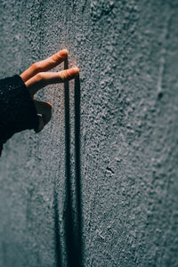 Cropped hand of woman with painted wall