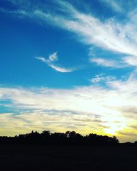 Scenic view of silhouette field against sky at sunset