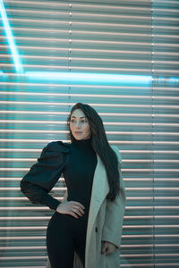 Young woman standing against wall