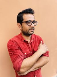 Portrait of young man standing against wall