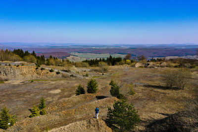 Rear view of man on landscape against blue sky