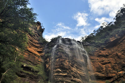 Low angle view of waterfall against sky