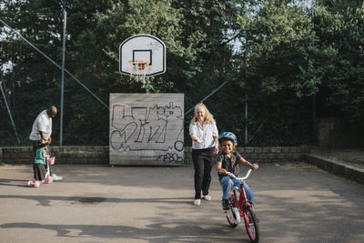 Parents and daughters spending time actively in park