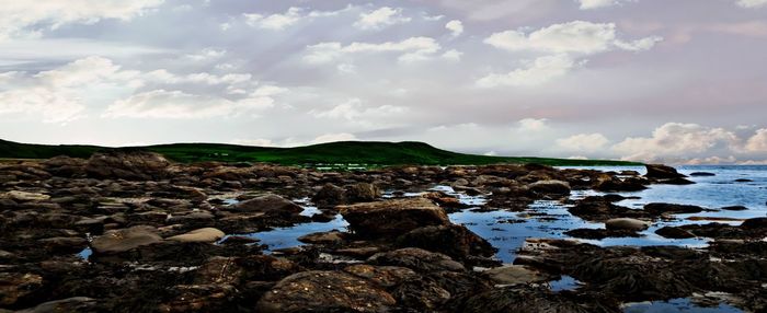 Rocks on sea shore against the sky