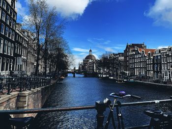 Canal amidst buildings against sky in city
