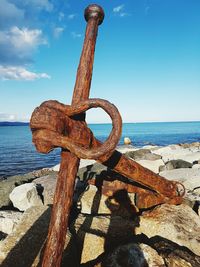 Close-up of cross on beach against sky