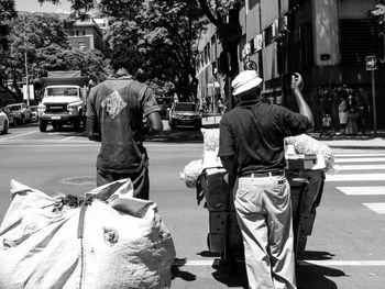 Rear view of people walking on city street