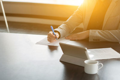 Close-up of woman hand holding book on table