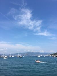 Boats sailing in sea against blue sky