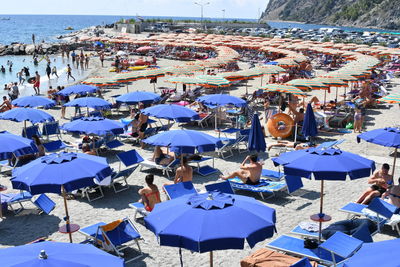 High angle view of parasols and people on beach against sky