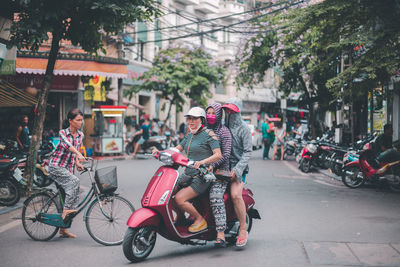 People riding bicycle on road in city