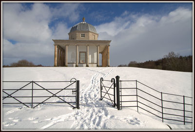 Built structure on snow covered landscape against sky