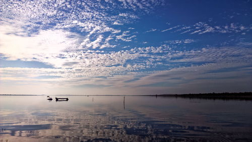 Scenic view of calm sea against cloudy sky